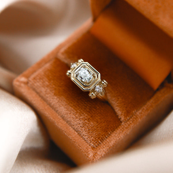 close up of the Diana 14K engagement tank ring, set with 6 adornment. diamonds and 1.5 ct diamond at its center. 