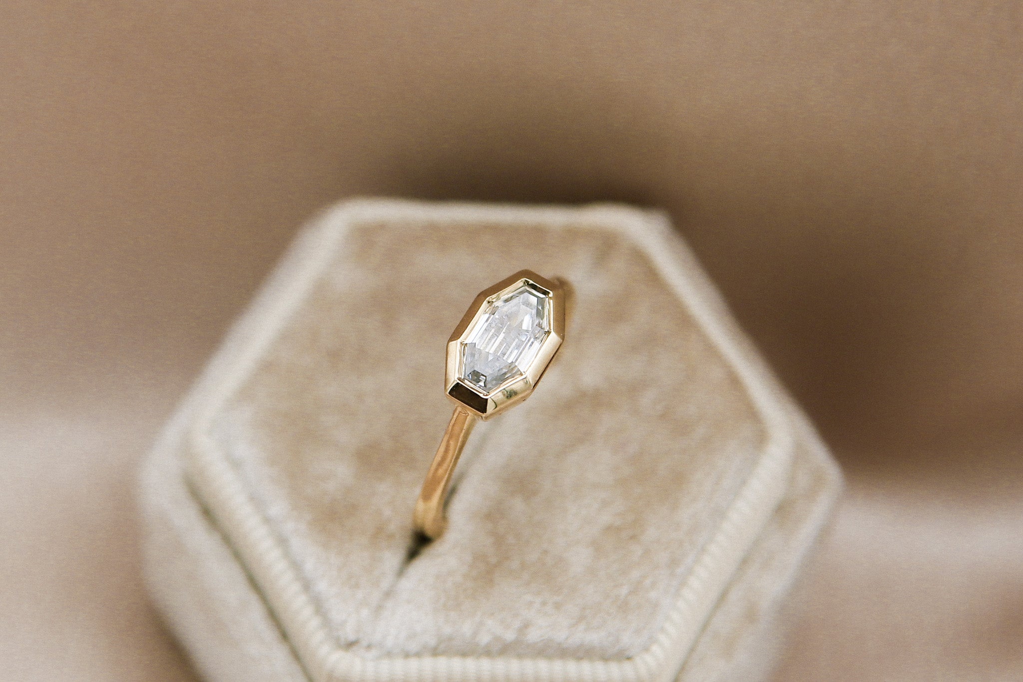 The perfect diamond engagement ring Milwaukees best jewelry store Cival Collective. Solid gold cast design is unique, modern and one of a kind. Faceted bezel set moissanite is a wonderful alternative to diamonds. Made by local Jewelry designers Re Frye and Nina Palacio. Gray Solitair is set east west with a custom cut step cut center stone