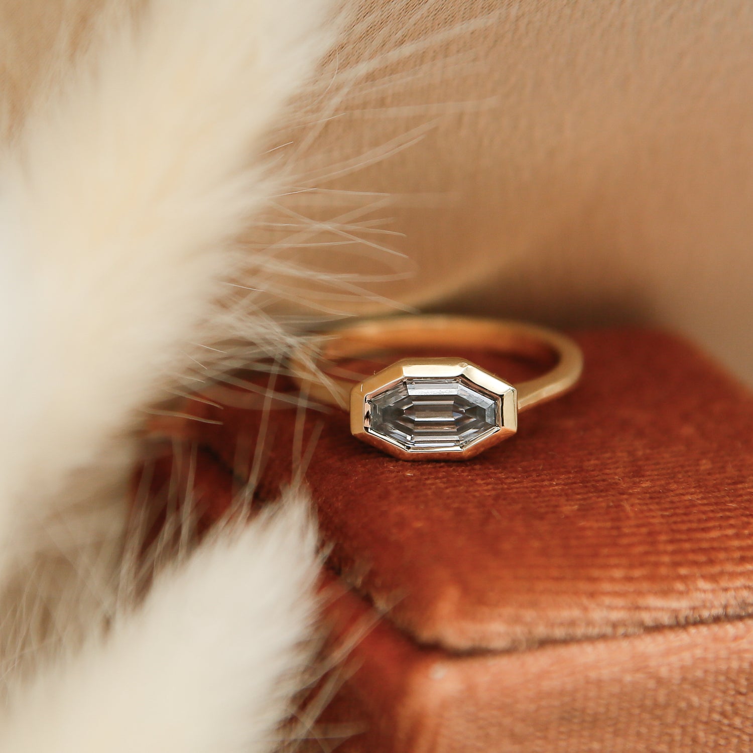 The perfect diamond engagement ring Milwaukees best jewelry store Cival Collective. Solid gold cast design is unique, modern and one of a kind. Faceted bezel set moissanite is a wonderful alternative to diamonds. Made by local Jewelry designers Re Frye and Nina Palacio. Gray solitaire is set east west with a custom cut step cut center stone