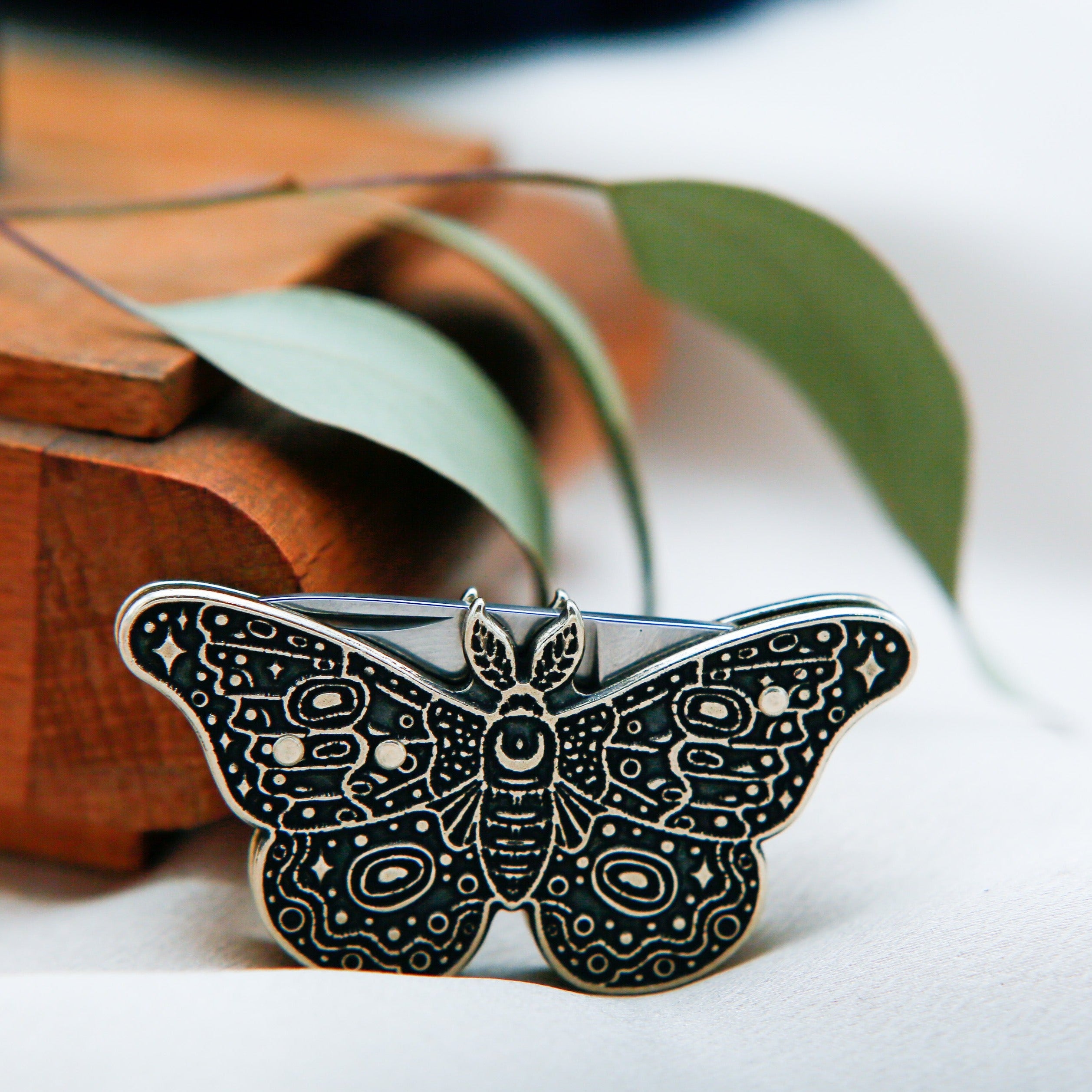 small pocket knife shaped as a moth, with dark patina. found at cival collective in milwaukee wisconsin