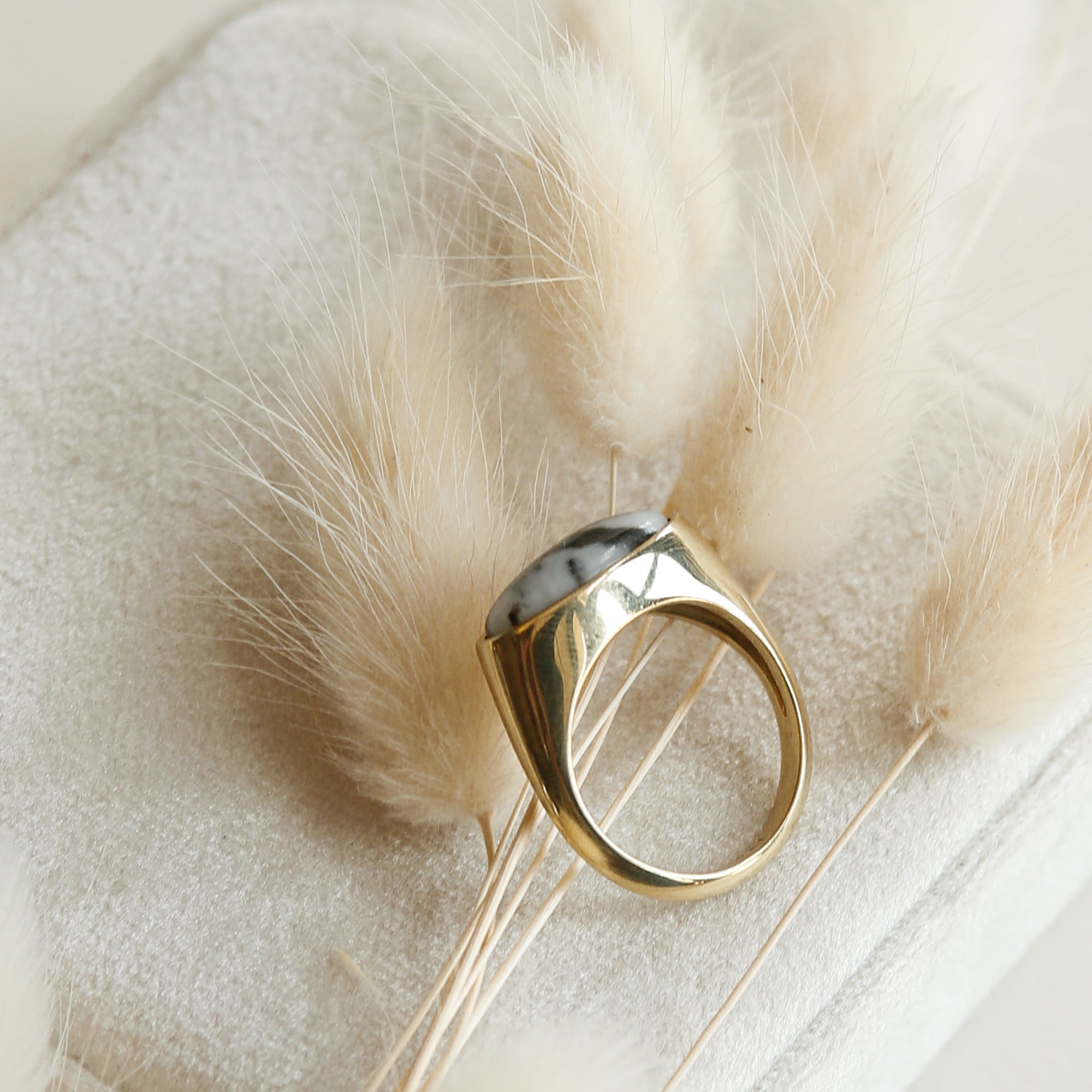Side view of brass cast dome ring with east west facing oval stone.