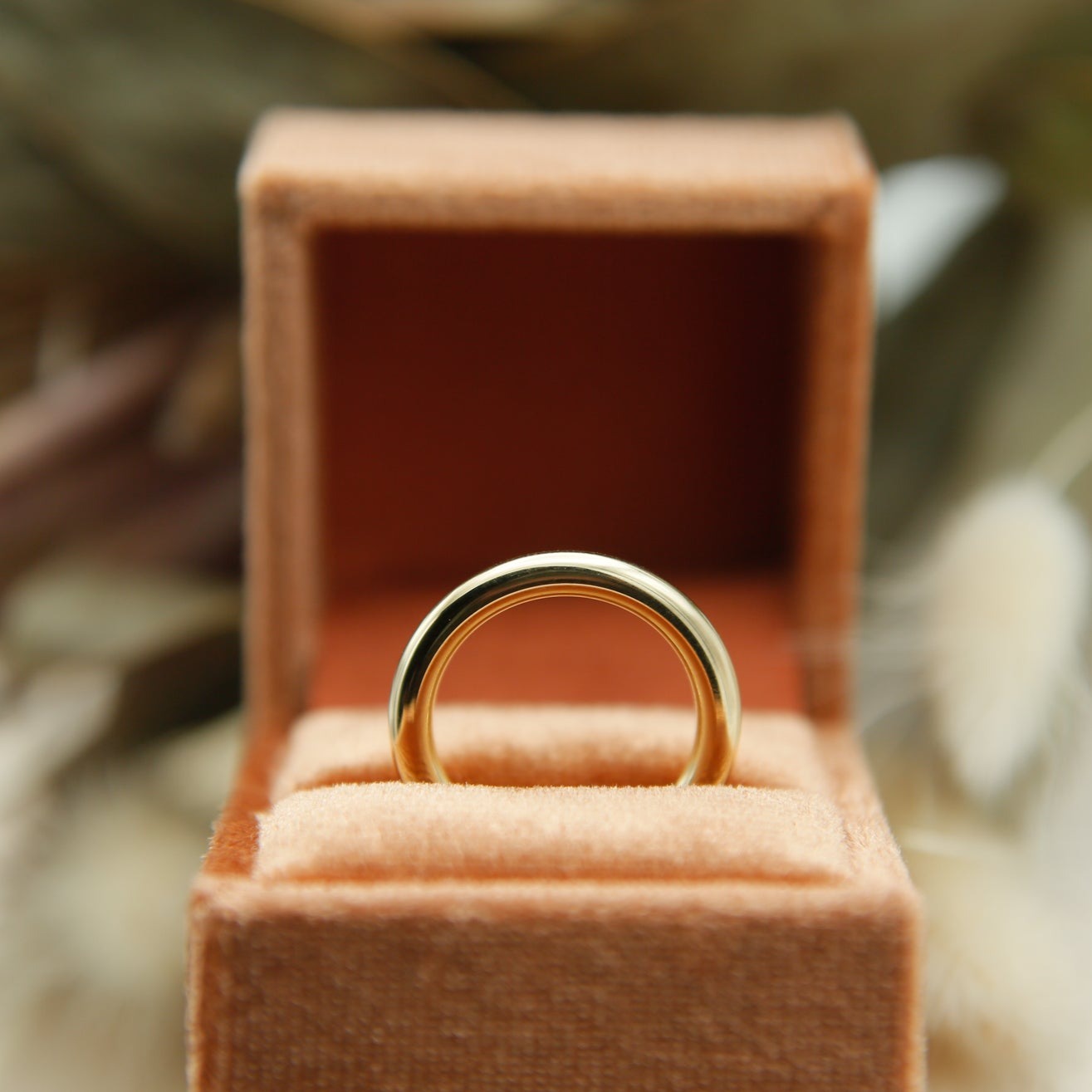close up of 10k 3mm round solid gold ring in velvet box