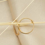 close up solid 14k gold hoops with thin tapper