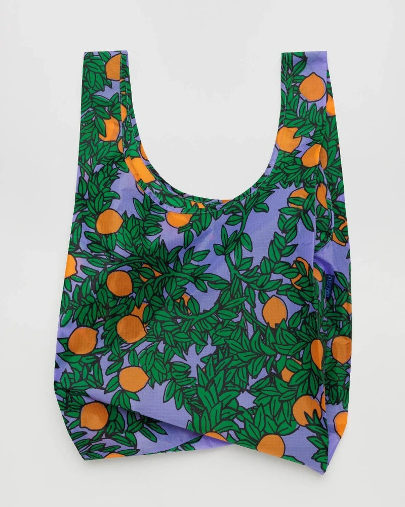Open baggu standard size reusable bag in the orange tree print colors are orange periwinkle blue orange and green with a orange tree foliage pattern 