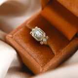 close up of the Diana 14K engagement tank ring, set with 6 adornment. diamonds and 1.5 ct diamond at its center. 