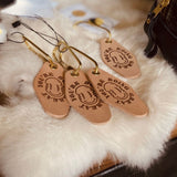 Leather keychain with brass loop, image of wavy smiley face and text “you’re doing great” 
