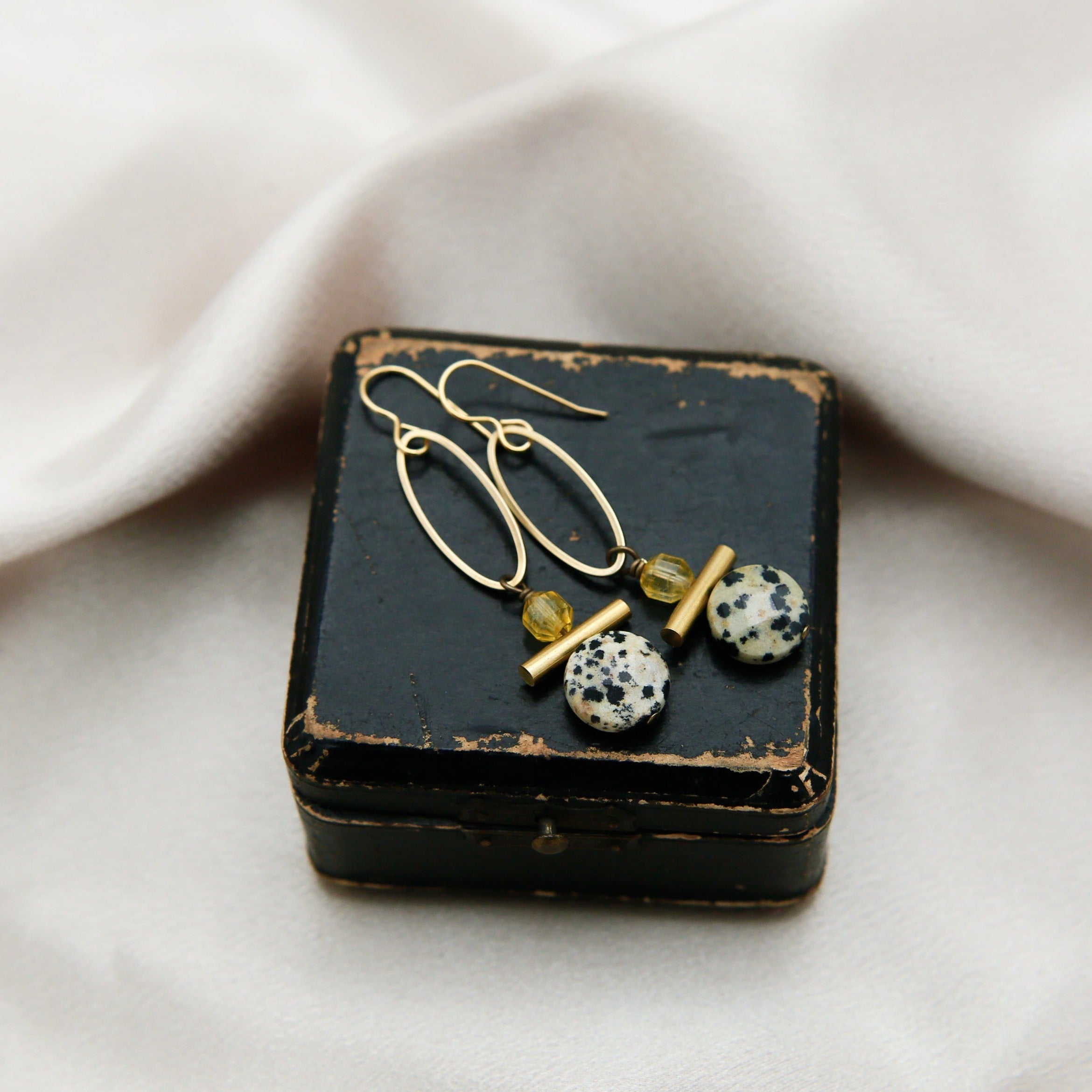 Close up of citrine and Dalmatian jasper on brass components. 