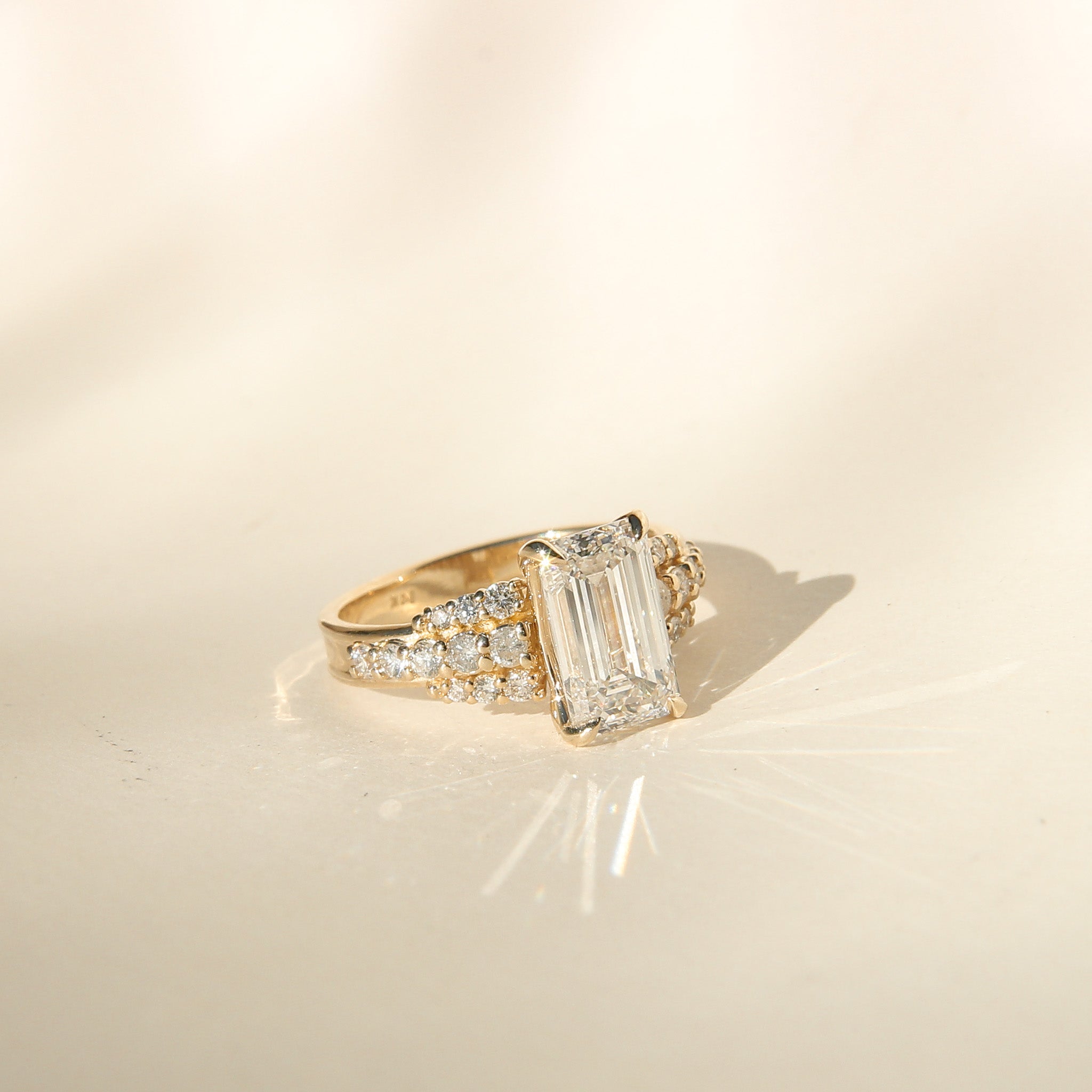 Emerald Cut Engagement ring set in yellow gold with accent stones 