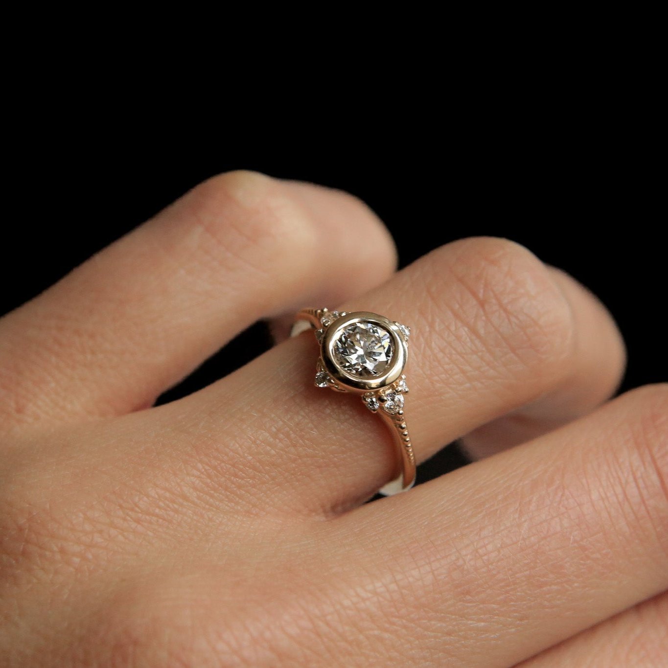 Vintage style diamond engagement ring with tiny diamond accents on hand