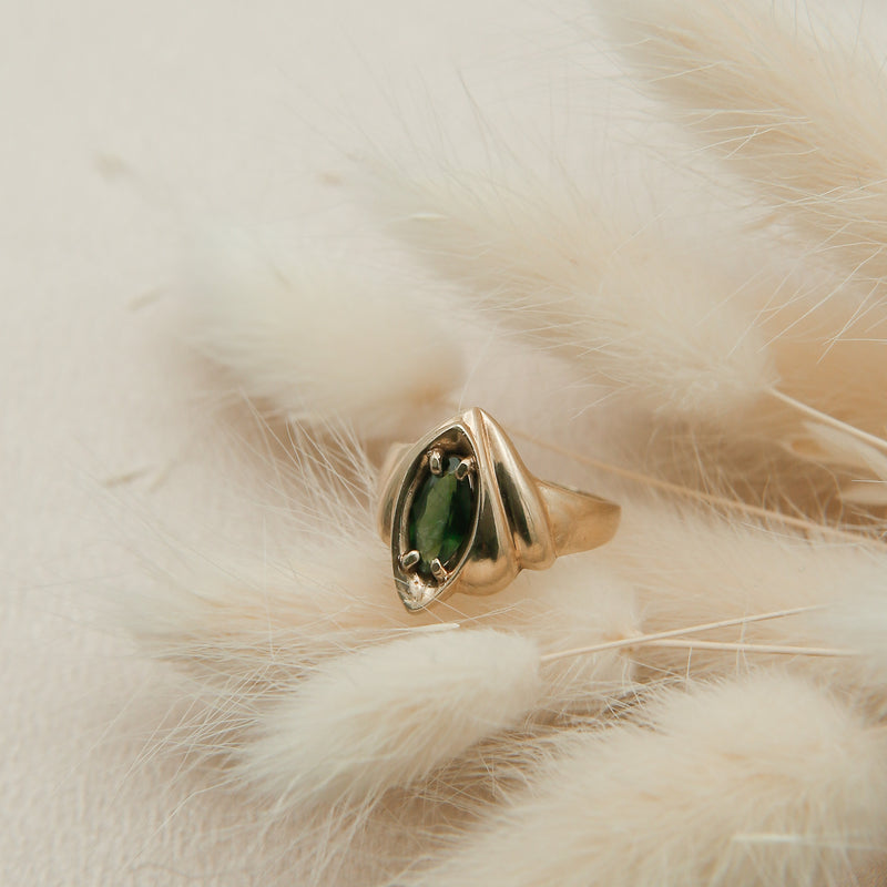 Close up of a restored 1980's vintage ring with a marquise cut Green Sapphire 
