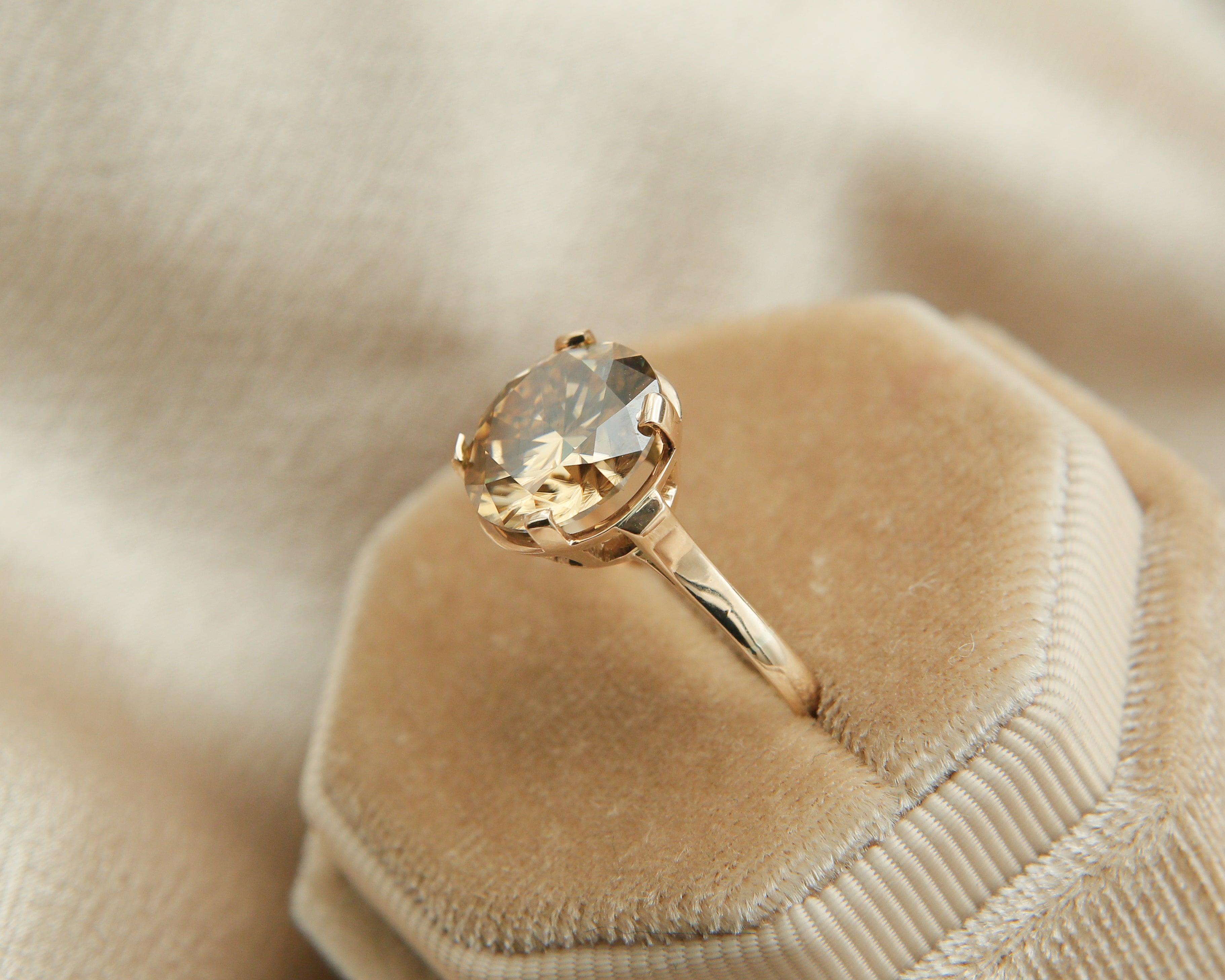 close up of 5ct pink moissanite with gold band 