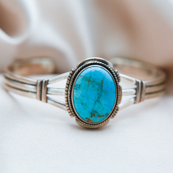 sterling silver cuff featuring a large oval shaped Kingman turquoise center stone