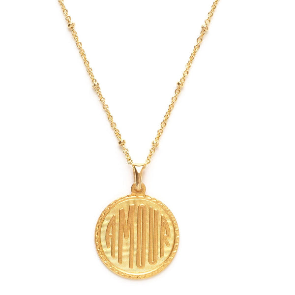 gold plated round pendant with "amour" etched onto the front, on gold satellite chain. 