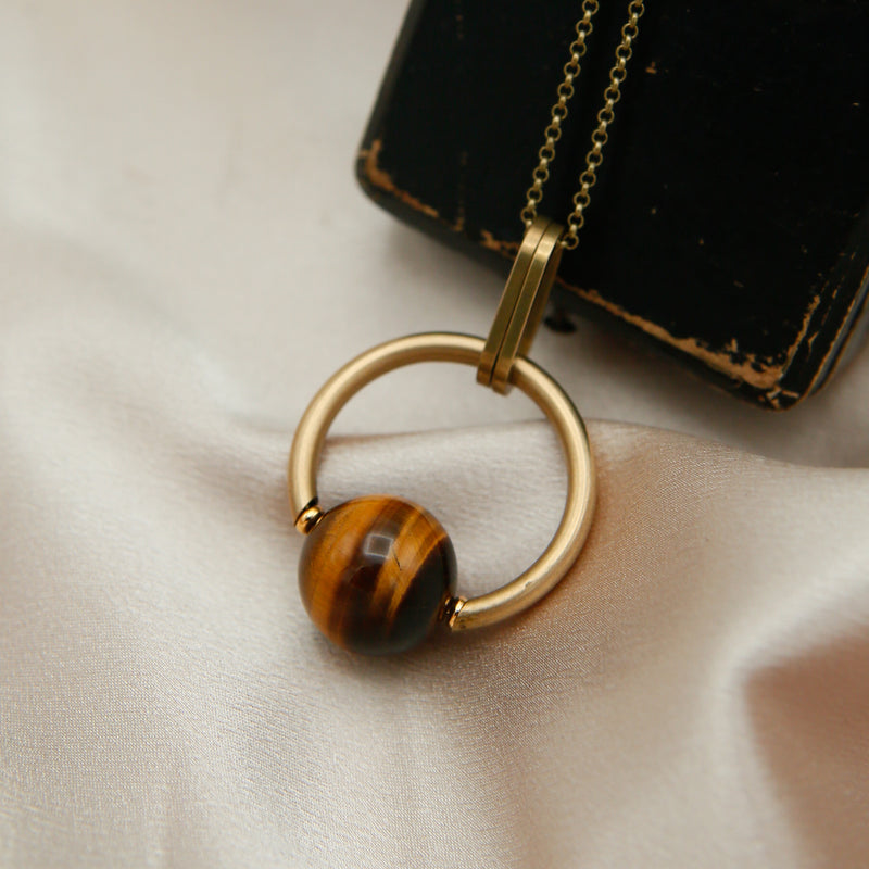 A tiger's eye necklace with brass details hand made at Cival Collective