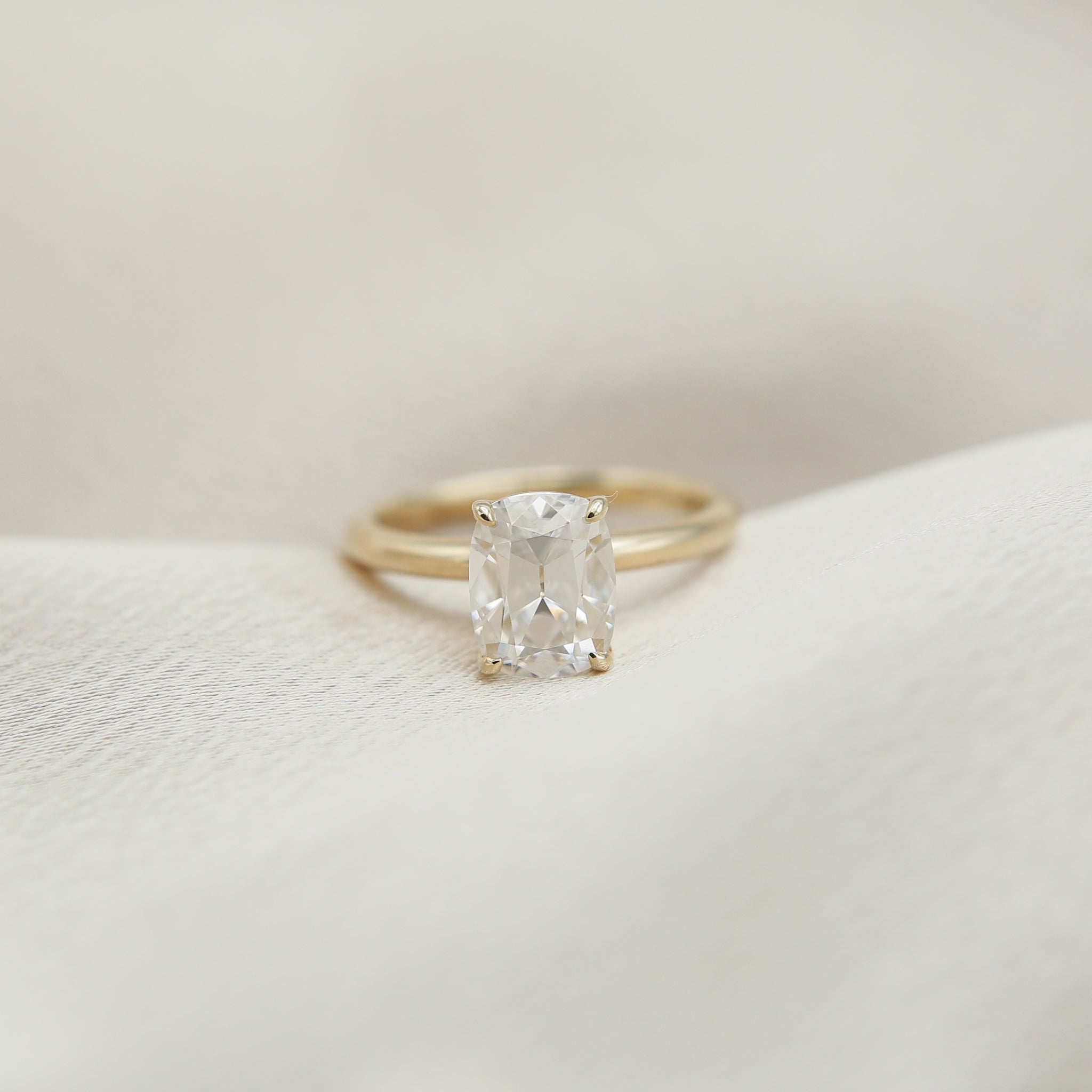 2ct Antique Cushion cut moissanite diamond engagement ring on a yellow gold band, by Unique Milwaukee Jewelry Store Cival Collective. Expertly crafted gold ring stacks with any style wedding band.