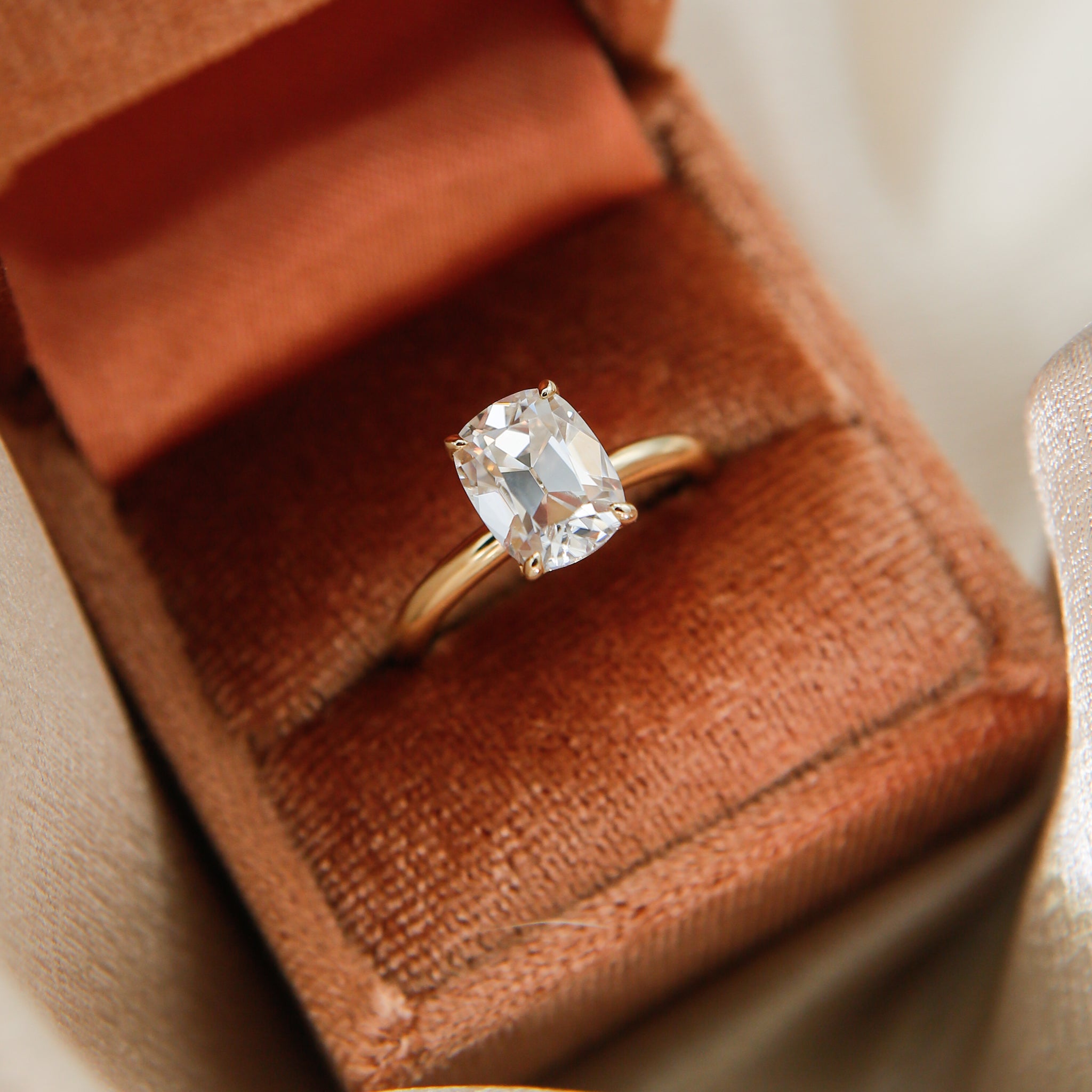 2ct Antique Cushion cut moissanite diamond engagement ring on a yellow gold band, by Unique Milwaukee Jewelry Store Cival Collective. Expertly crafted gold ring stacks with any style wedding band.