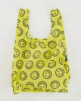 Open baggu standard size reusable bag in the yellow happy print colors are bright yellow and black smile face pattern