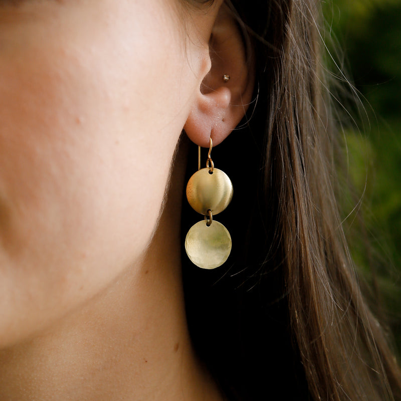 close up of marcia earrings on model, drop earring with brass rounds