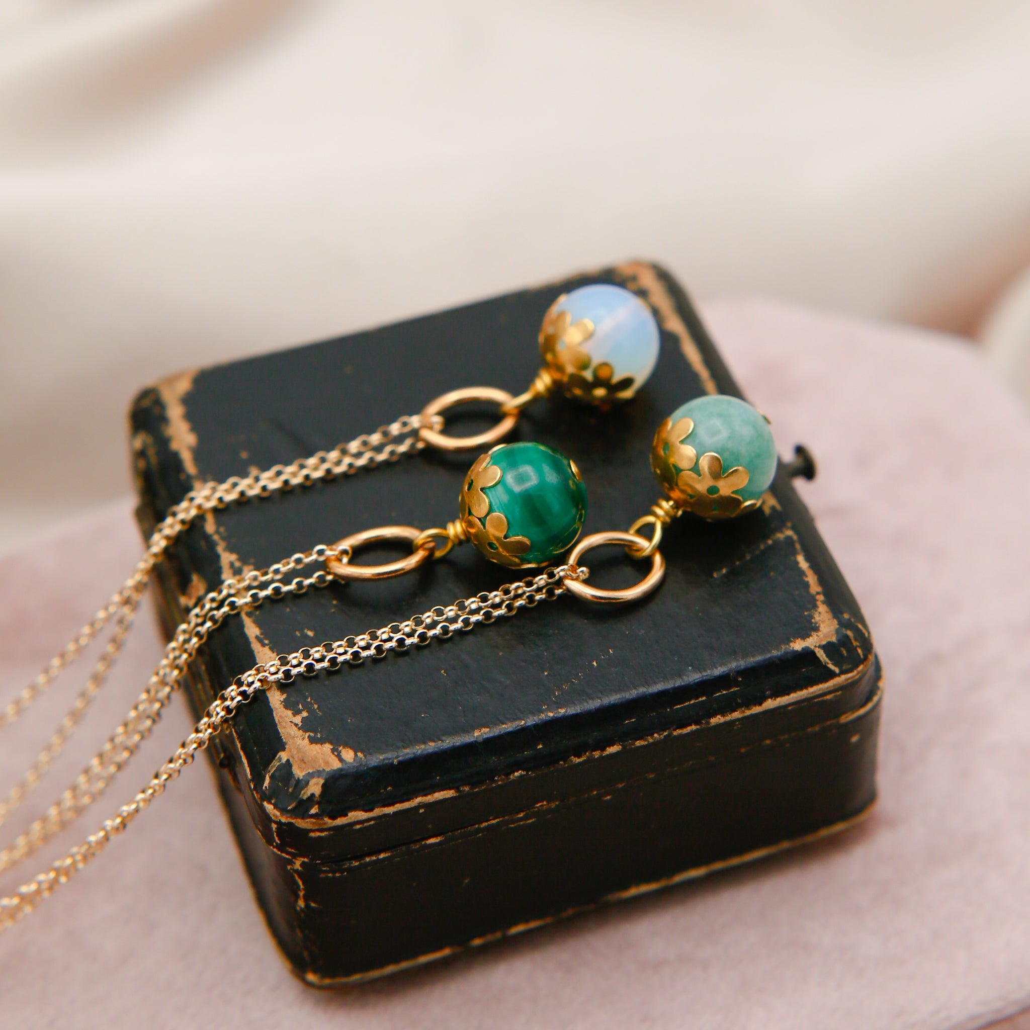 three round stone necklaces with a brass daisy cap. designed at cival collective, a jewelry store in Milwaukee, WI