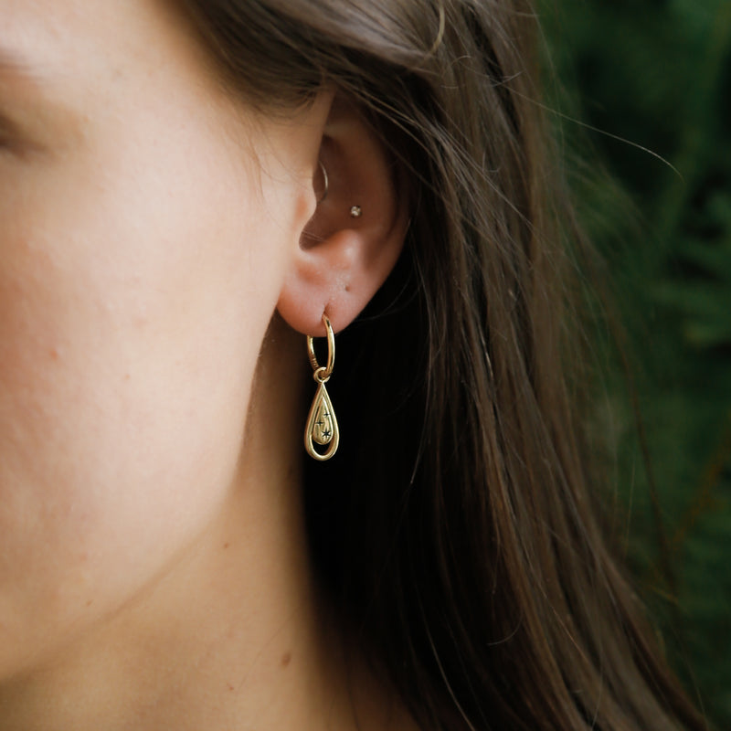 Dainty everyday sparkle tear charm earrings on gold hops  