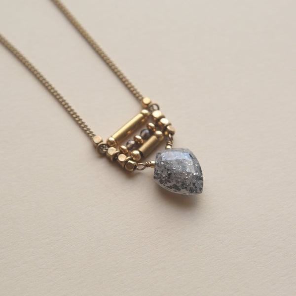 A gray sunstone and beaded brass necklace made at Cival Collective, a jewelry store in Milwaukee.
