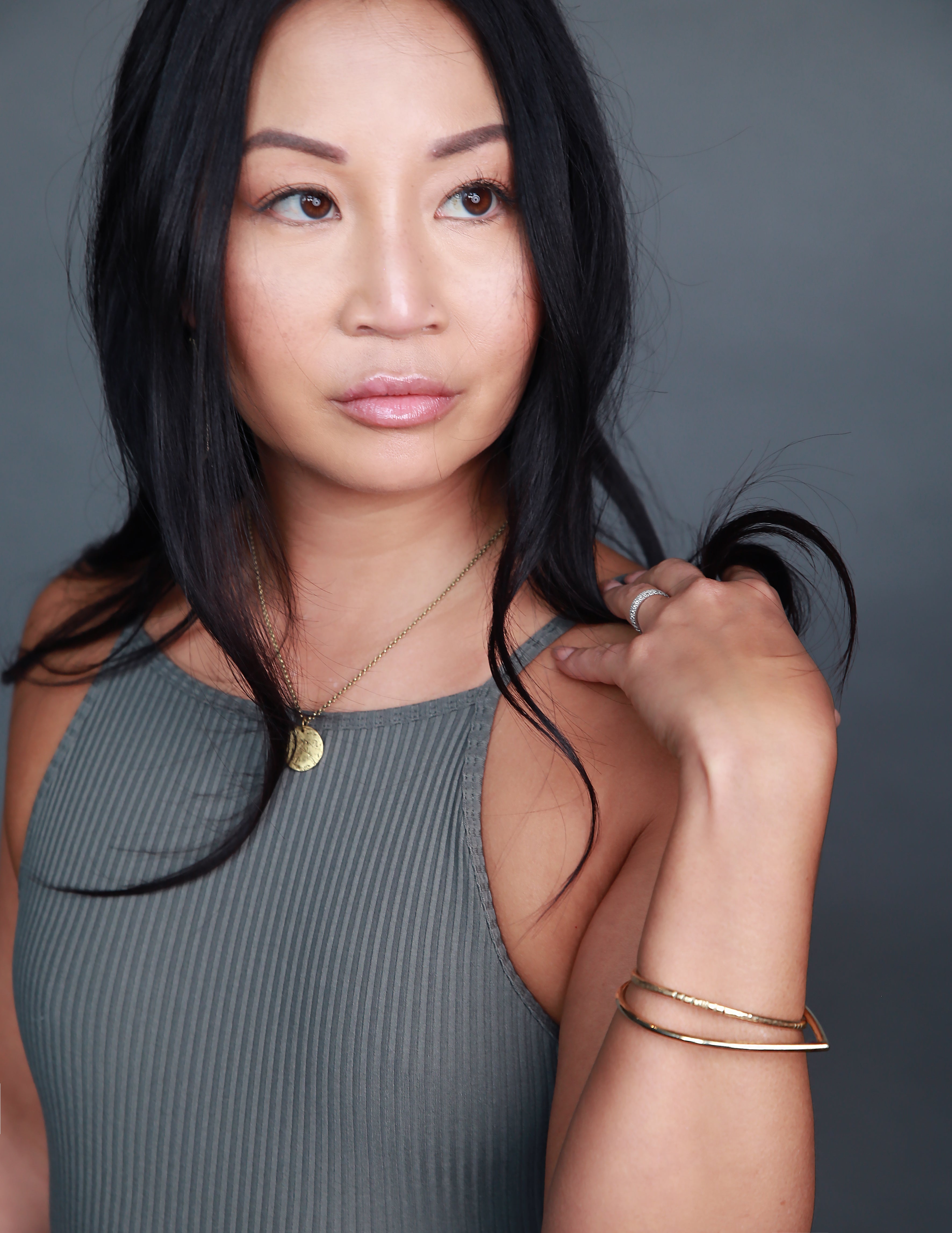 Model wearing handmade brass jewelry by designers Cival Collective.