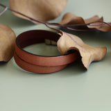 "Acer" 10mm wide leather double wrap bracelet in tan and displayed on it's side with brown leaves.