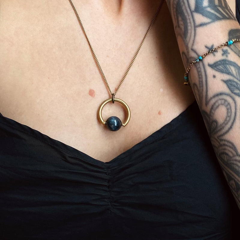A solid brass suspension necklace with a blue kyanite center stone. Designed at Cival Collective, a jewelry store in Milwaukee, WI. 