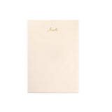 light pink notepad with gold lettering "list" on the top of page