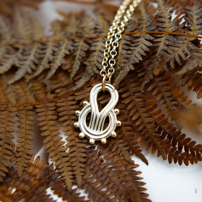 Cast brass amulate necklace designed in house at Cival Collective, a jewelry store in Milwaukee WI