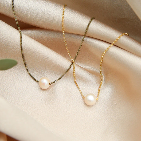 two natural pearl choker necklaces. one is on a brass chain while the other is a gold fill chain. designed at Cival Collective, a jewelry store in Milwaukee WI