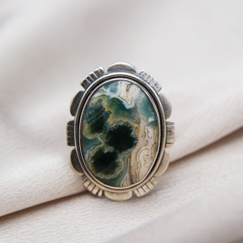 Intricate silver adjustable crossover band with vintage petal details. Featuring a Large Incredible oval ocean jasper. This Ocean Jasper is roughly 30-40 years old. Many of the mines these stones are from no longer exist, making them very rare.
