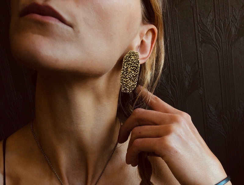 Model wearing brass geometric, gem inspired & organic texture stud statement earrings by CIVAL Collective.