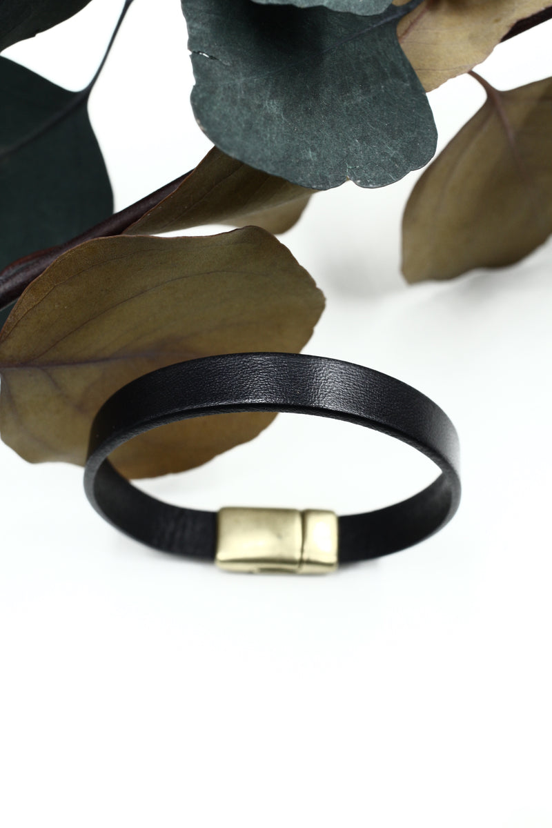 CIVAL Collective's "Ace" wide leather bracelet in black with magnetic brass clasp displayed upright on white background.