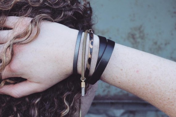 Model wearing black leather 10mm wide double wrap bracelet on wrist with other leather bracelets all made by CIVAL Collective.