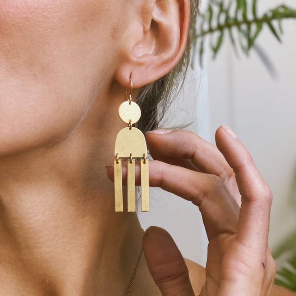 Close up of CIVAL's geometric stack brass "Alana" earrings.
