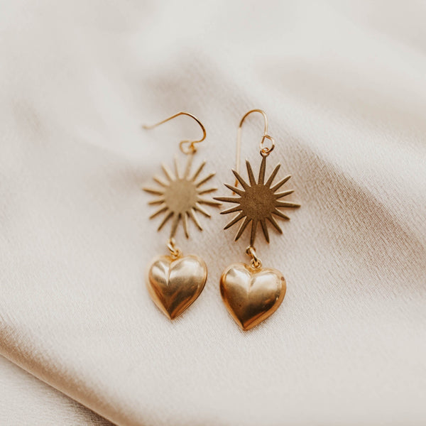 Close up of Beryl earrings, sunburst and brass heart drop earrings 
