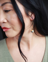 Modern woman modeling dalmatian jasper stone and brass earrings crafted by local Milwaukee Jewelry Designers, Cival Collective.