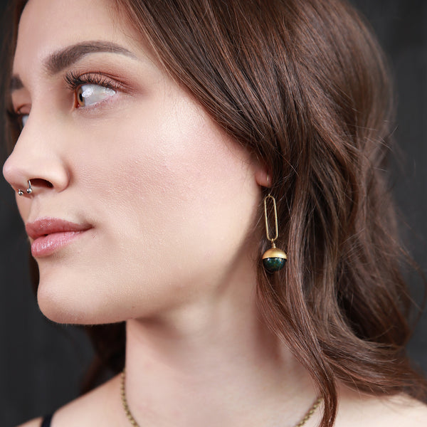 Young woman modeling green agate and brass earrings crafted by local Milwaukee Jewelry Designers, Cival Collective.