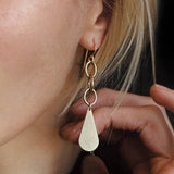 close up of josie earrings on model, brass teardrop and chain style 