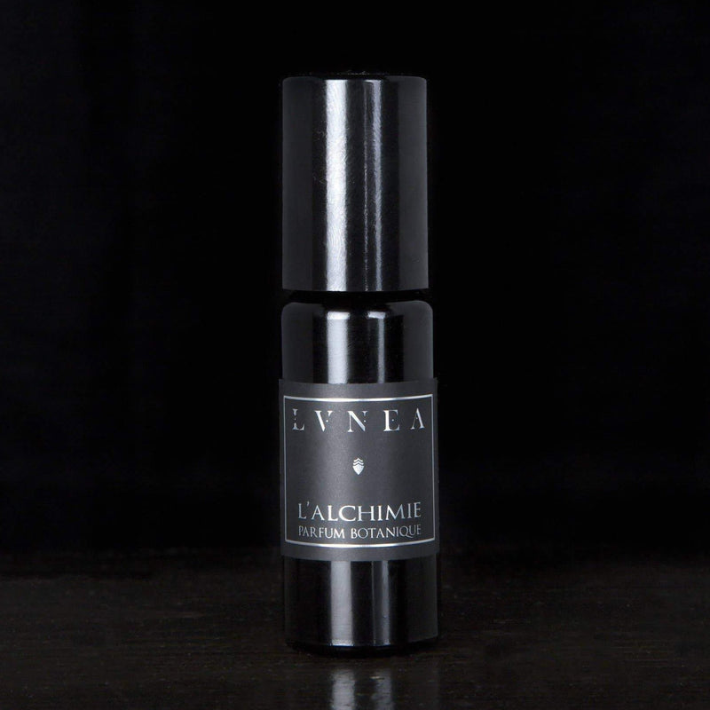 Black perfume bottle labeled "LVNEA" L'alchimie set with black background. 
