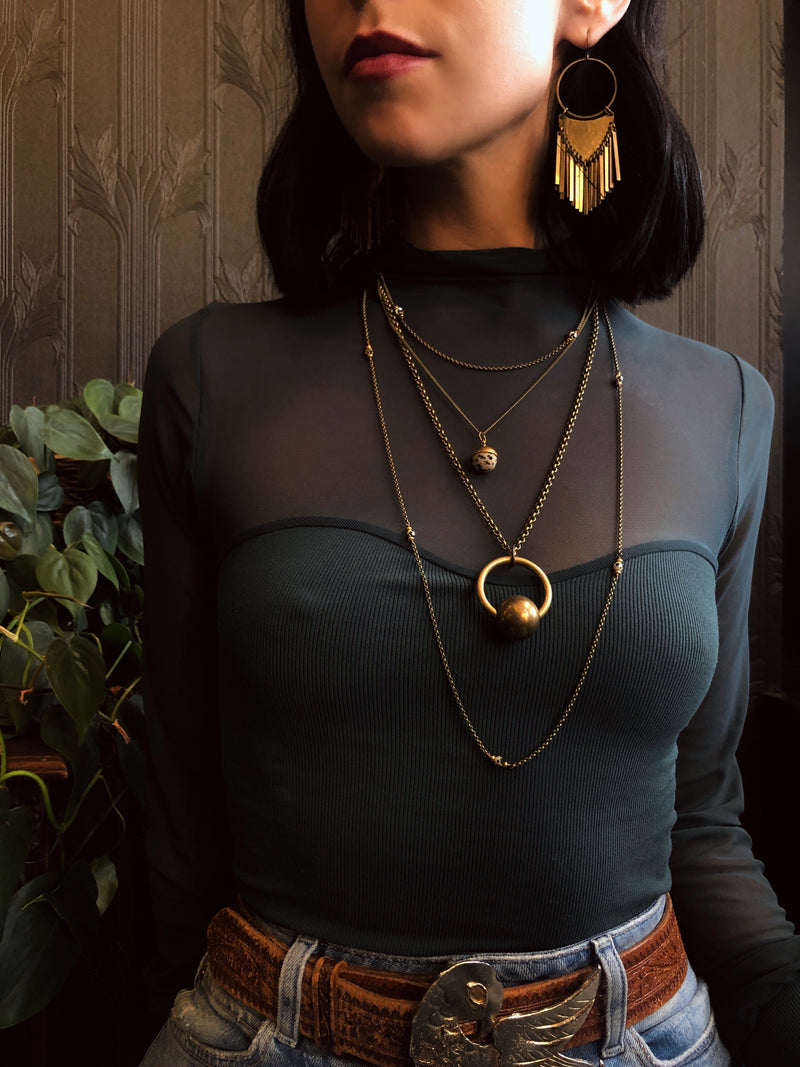 Three necklace layering set including two Dalmatian jasper necklaces & a brass sphere suspension necklace. Pictured on model from CIVAL Collective in Milwaukee WI. Also on model are the brass Dana earrings.