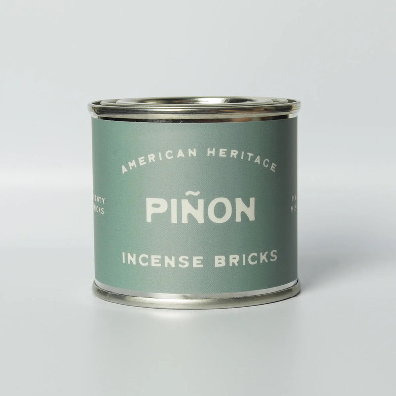 tin of incense bricks, light green label reading "american heritage pinon incense bricks" 